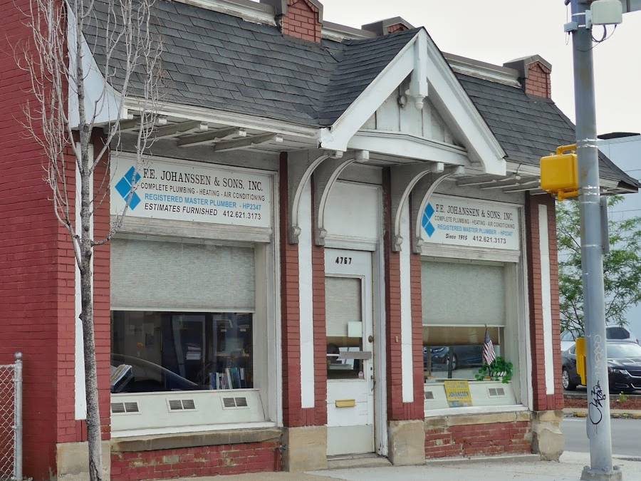 The red-brick F.E. Johanssen & Sons shop front, with two painted window signs listing plumbing, heating, air conditioning, registered master plumber and the phone number 412.621.3173.